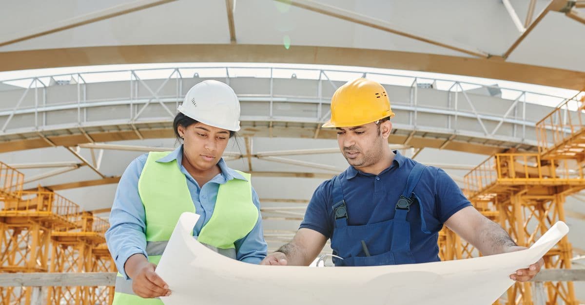 Bauunternehmer im Gespräch mit einem Kunden auf der Baustelle beim ersten Auftrag