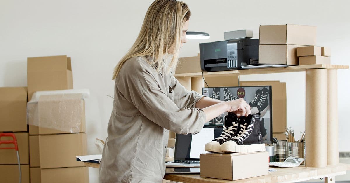 Verkäuferin verpackt ein handgefertigtes Produkt für den Versand nach der ersten Etsy-Bestellung