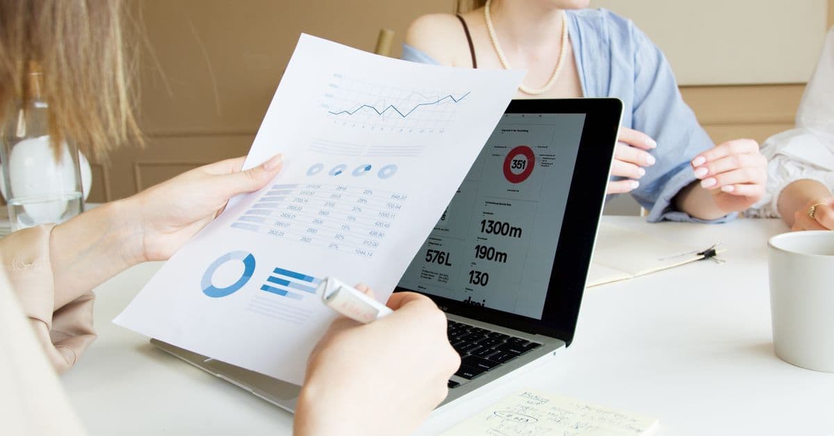 Nahaufnahme von Fachleuten, die in einer Besprechung Finanzgrafiken auf einem Laptop prüfen