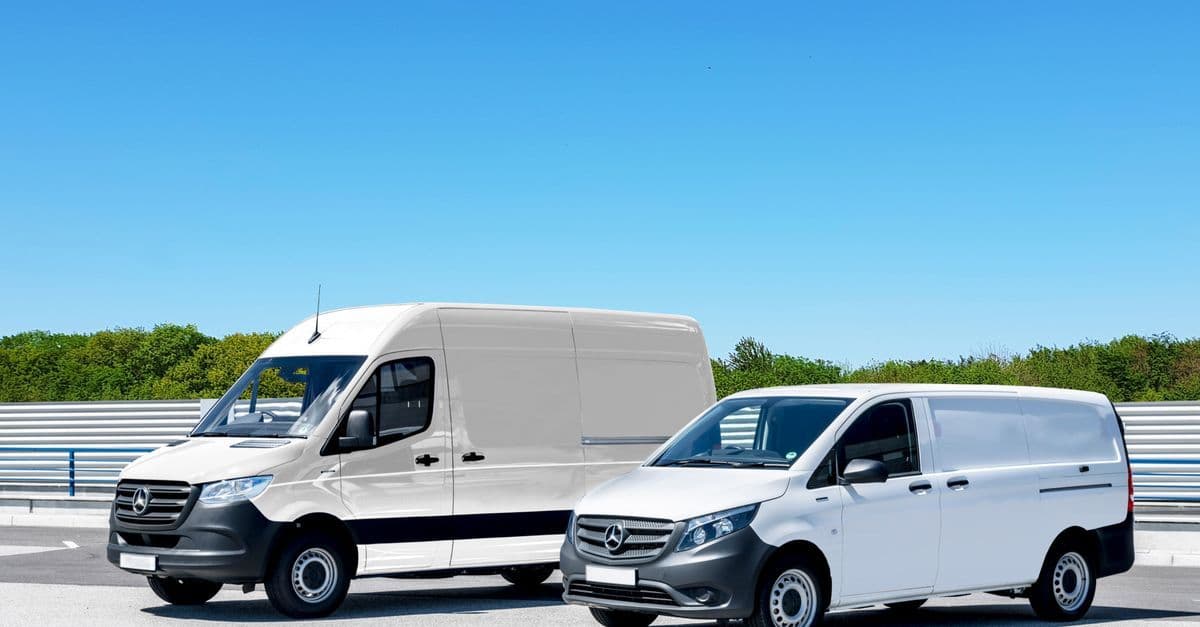 Zwei weiße Lieferwagen auf einem großen Parkplatz unter klarem blauem Himmel