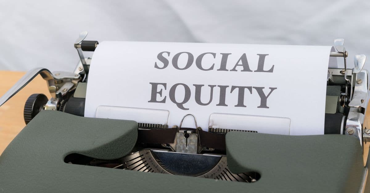 Close-up of a vintage typewriter displaying the message 'Social Equity' on paper.
