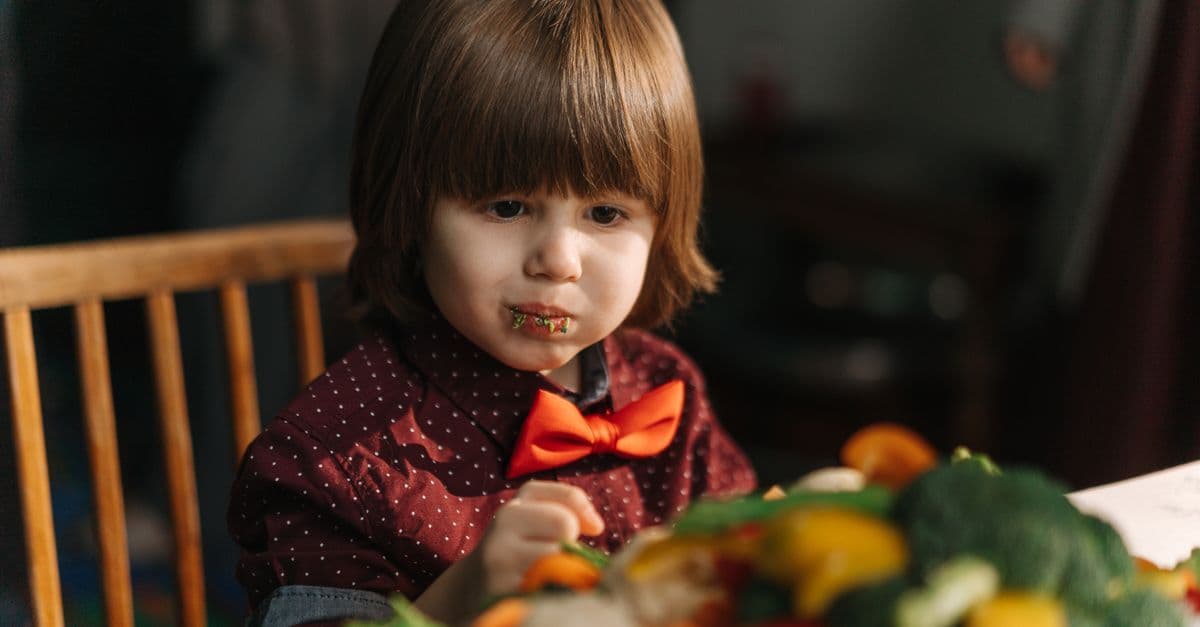 Ein kleines Kind isst Gemüse – Sinnbild für den hohen Gemüseanteil in den Bio-Quetschies von Pumpkin Organics
