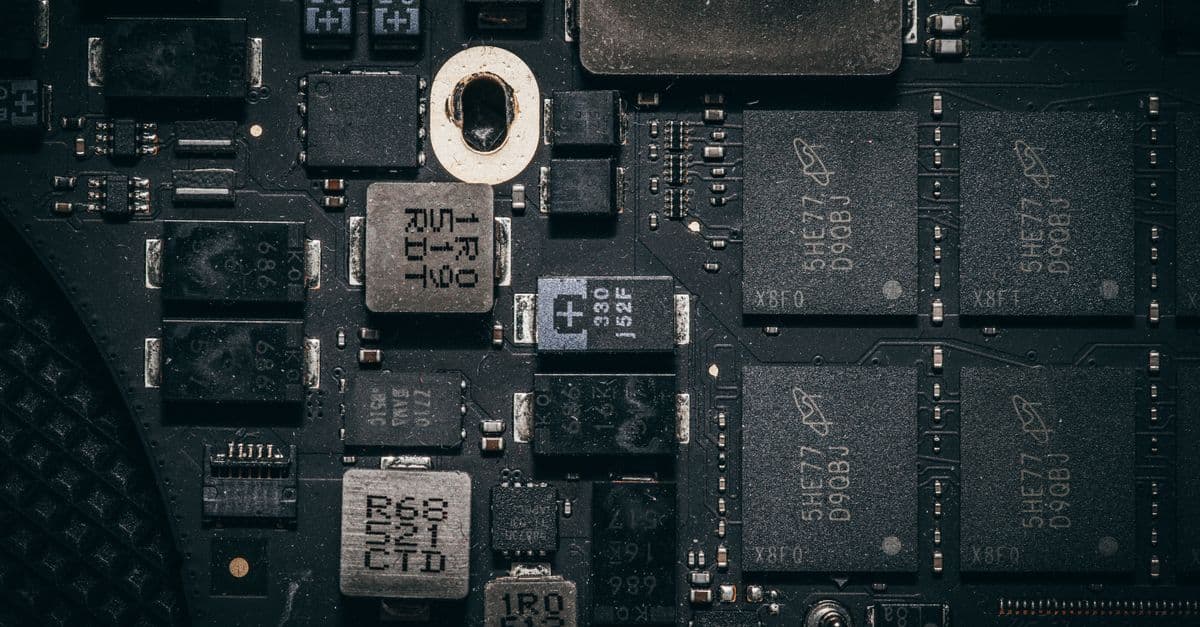 Nahaufnahme einer Computerplatine mit elektronischen Bauteilen und feinen Leiterbahnen.