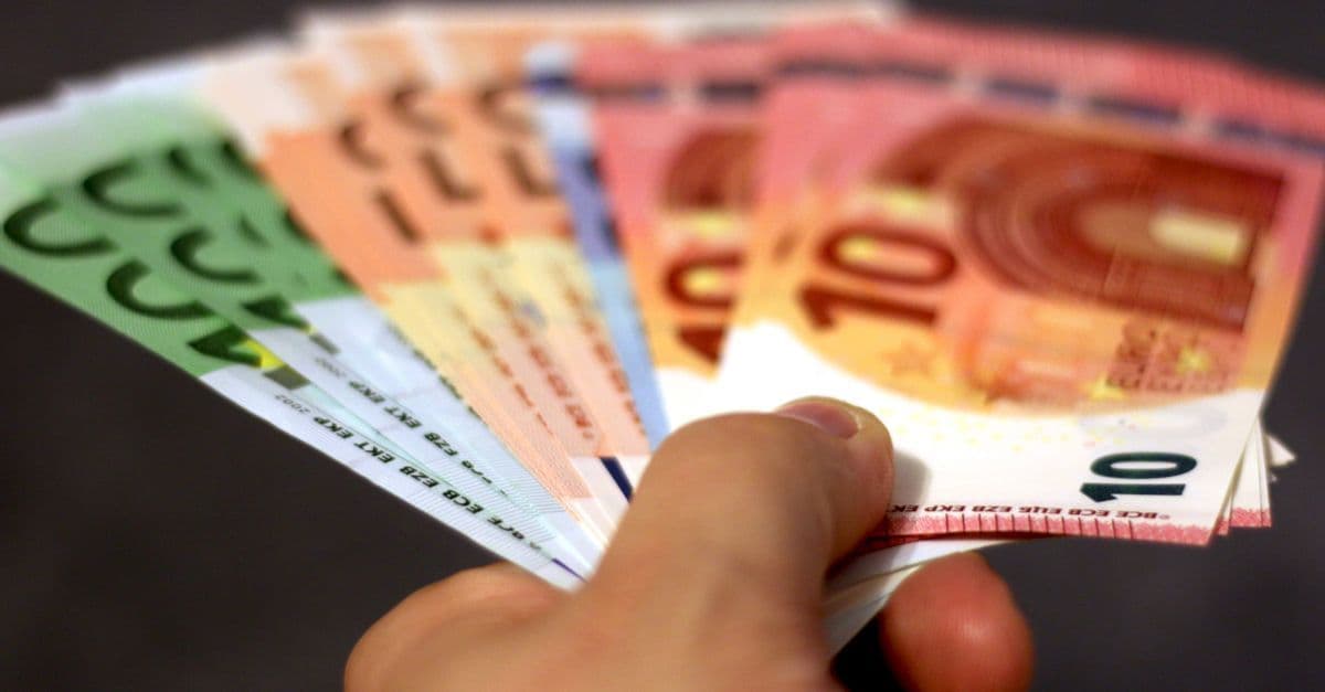Eine Hand hält einen Fächer aus Euro-Banknoten in Nahaufnahme.