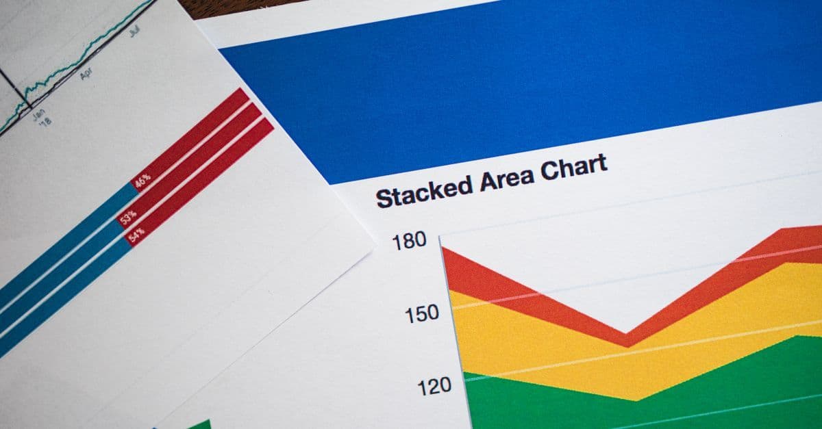 Gestapelte Flächendiagramme und weitere Grafiken auf Papier zur Datenanalyse