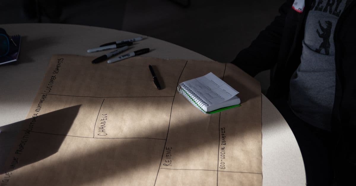Notizblock und Marker auf einem Tisch für ein Brainstorming, in gedämpftem Licht.
