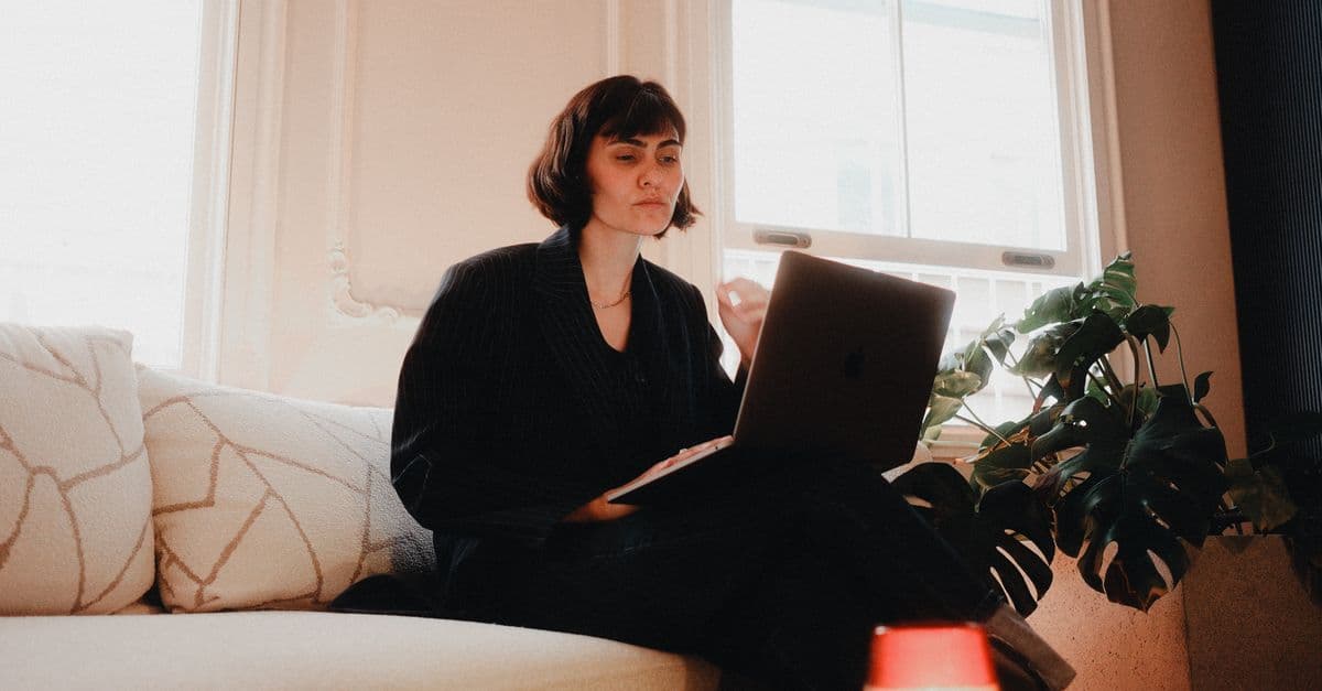 Frau arbeitet konzentriert am Laptop im Homeoffice als virtuelle Assistentin
