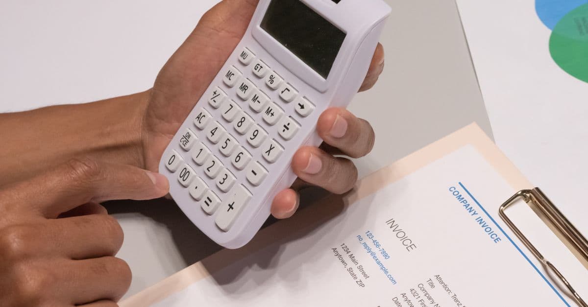 Rechnungen und Taschenrechner auf einem Schreibtisch zur Kostenplanung im Finanzplan