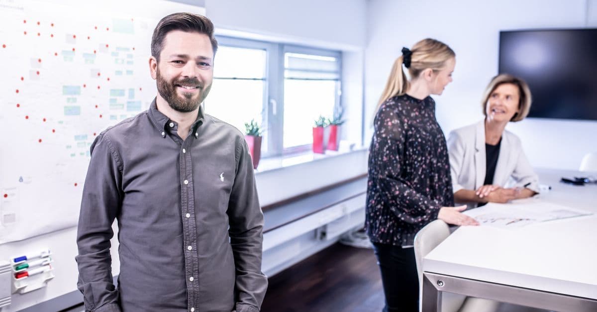 Smiling team meeting in office space with collaborative atmosphere and modern interior.
