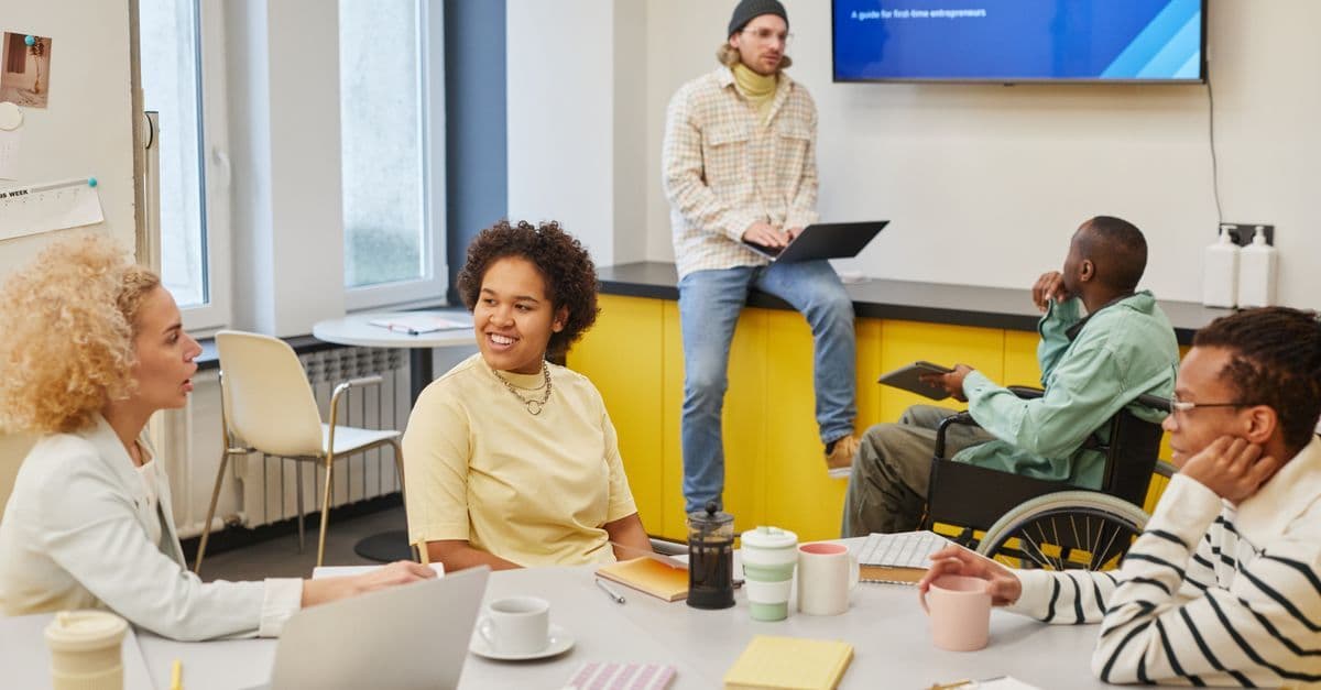 Diverses Team diskutiert in modernem Büro bei Workshop vor digitaler Präsentation ein Startup-Projekt