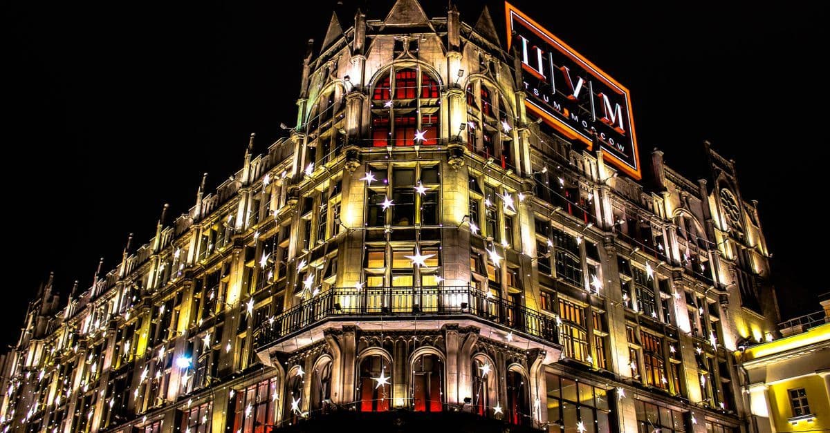 A captivating night view of a historic building illuminated with neon lights and decorated with stars.