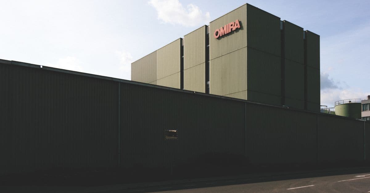 Modernes Industriegebäude mit großer Metallfassade unter klarem Himmel.