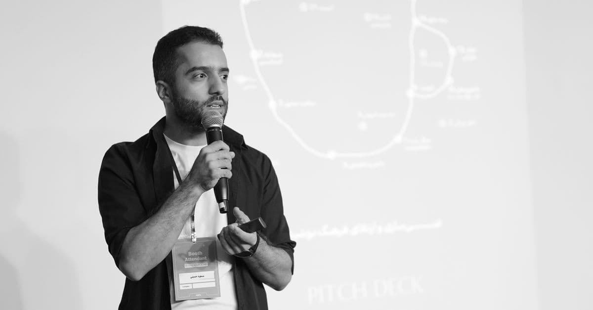 Man speaking into a microphone during a business seminar presentation.