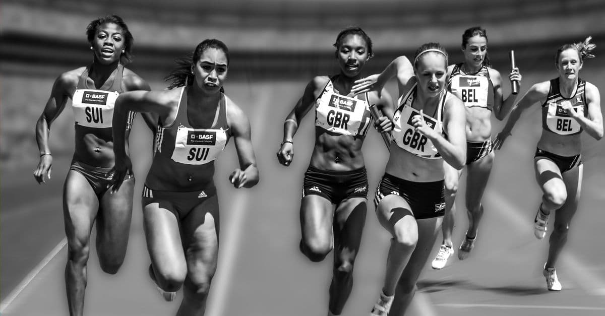 Female athletes in a high-stakes track race showcasing physical prowess and competition.