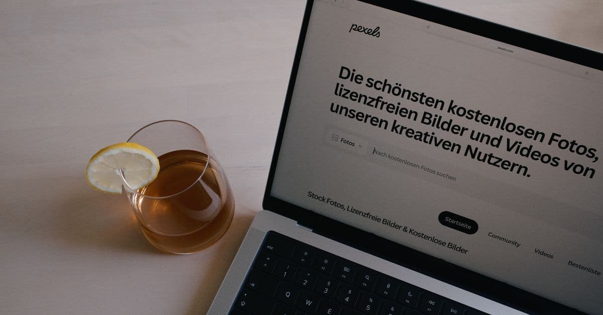 Laptop auf einem Schreibtisch neben einem Glas Zitronentee
